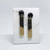 Two long rectangular shaped earrings made from black and gold resin